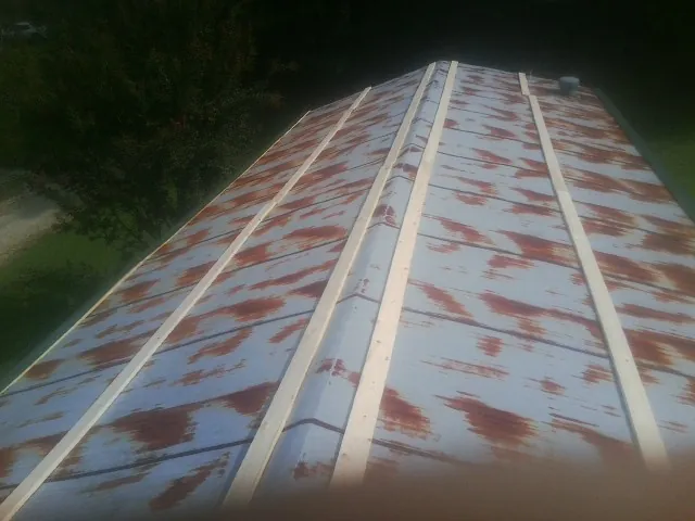 Rusted metal roof panels with new wood purlins before replacement — Storm Damage Roof Repair in Guymon by Roofing Brothers